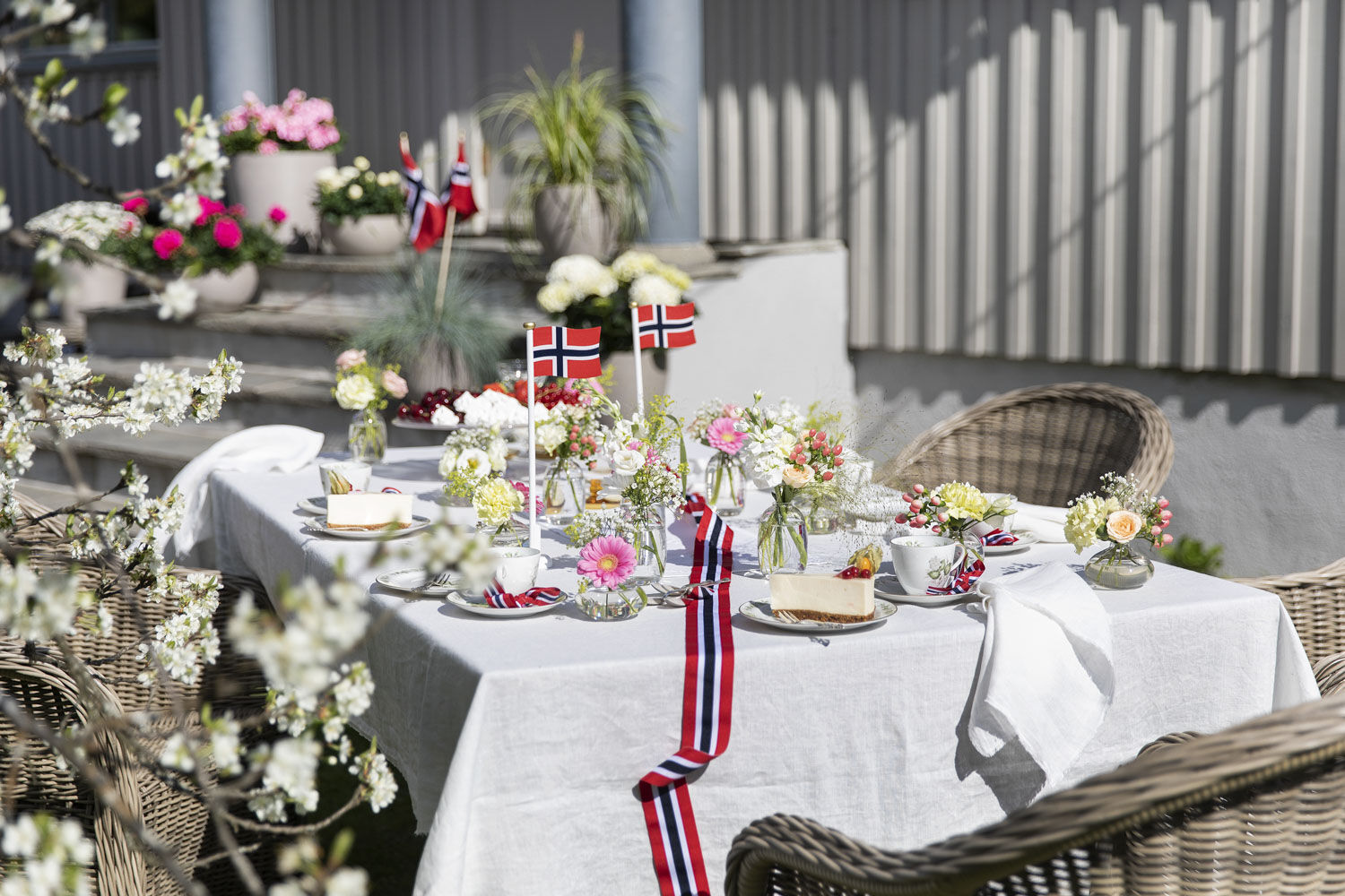 Pynt 17. mai-bordet med sm&aring; vaser med blomster i nasjonalfargene